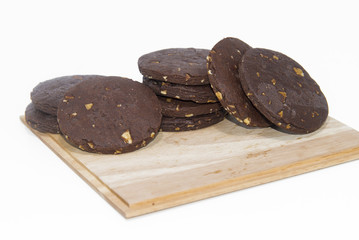 Stacked chocolate cookies with almonds on wood tray