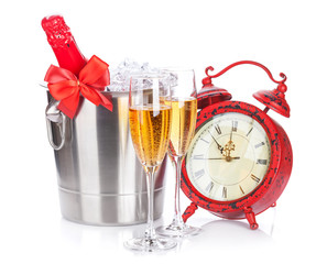 Two champagne glasses, bottle in cooler and clock
