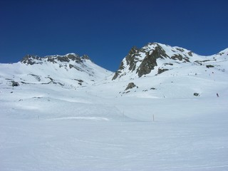 Fototapeta na wymiar Beautiful snowy winter landscape in a mountain ski resort, on a sunny afternoon. Ski slopes.