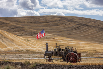 Steam engine and flag in field.