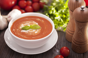 Delicious tomato soup with aromatic spices on a wooden table.