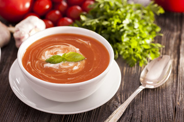 Delicious tomato soup with aromatic spices on a wooden table.