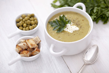 A delicious pea cream with aromatic spices on a wooden table.