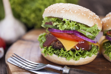Beef burgers on a wooden board with aromatic spices