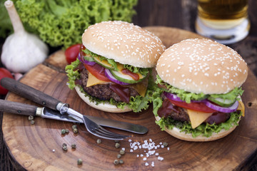 Beef burgers on a wooden board with aromatic spices