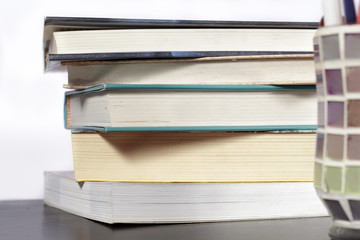 Stack of books on a wooden desk and white background