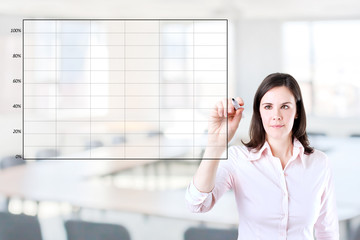 Fototapeta premium Young business woman drawing on empty graph. Office background.