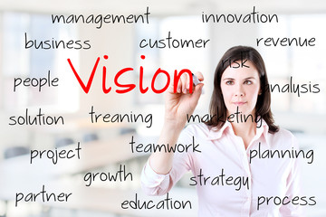 Young business woman writing concept of vision. Office background.