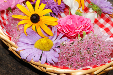 Blüten verschiedener Gartenblumen in einem Korb, Tischgedeck, Bl