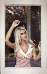 Blond beauty behind the window