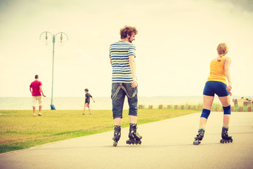 Young couple on roller skates riding outdoors