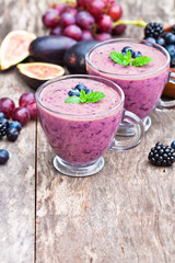 fresh healthy pulpy cocktail with purple fruits and berries