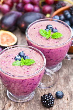 fresh healthy pulpy cocktail with purple fruits and berries