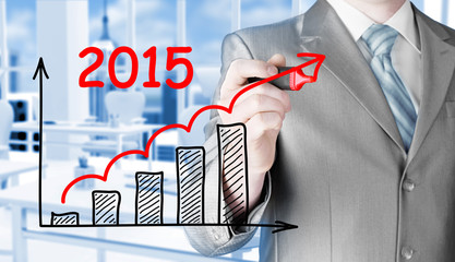 business man drawing growth graph for year 2015