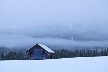 old wooden hut on snow in Alps