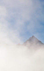 mountain peak in dense fog