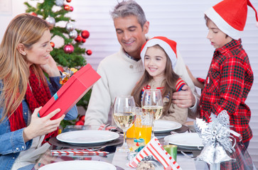 Happy family exchanging gifts for Christmas