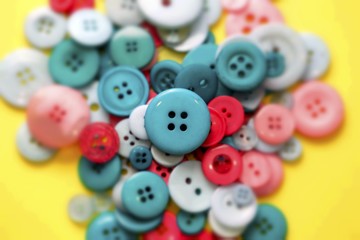 Green and red sewing buttons on yellow