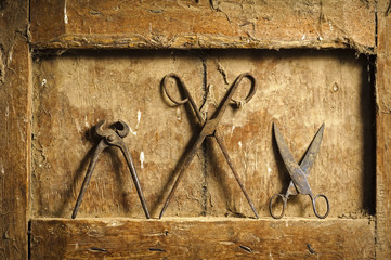 old  scissors and pliers tools on antique wooden panel