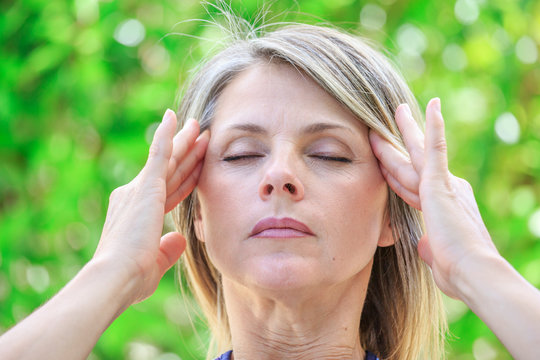 middle age woman with intense stress and painful headache