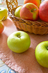 Green and red organic apples in basket