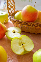 Green and red organic apples in basket
