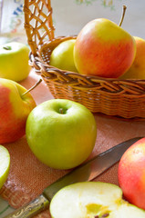 Green and red organic apples in basket