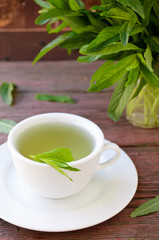 Cup of herbal tea with wild camomiles, mint and flowers
