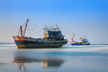 Sunset with wooden fishing boat in Thailand