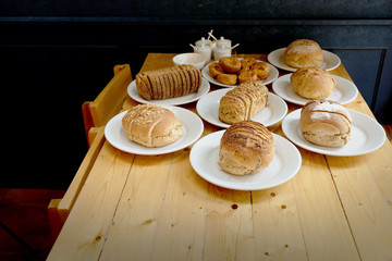 Baked bread on white plate and wooden table with Selective focus.