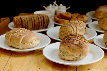 Baked bread on white plate and wooden table with Selective focus.