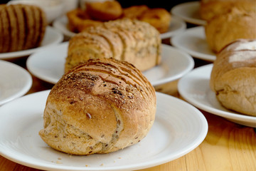 Baked bread on white plate and wooden table with Selective focus.