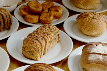 Baked bread on white plate and wooden table with Selective focus.