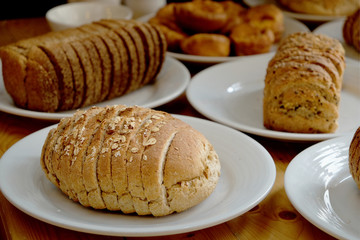 Baked bread on white plate and wooden table with Selective focus.