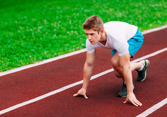 Athletic woman on track starting to run. Healthy fitness concept