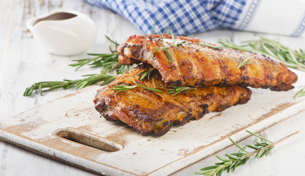 Grilled pork ribs  on a wooden cutting board.