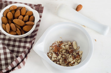 Almond nuts in a white mortar.