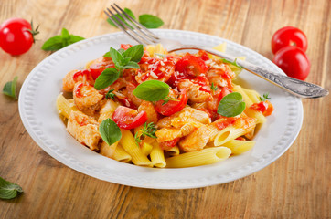 Pasta penne with chicken, tomato sauce and vegetables.