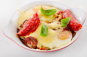 Baked eggs with cheese, tomatoes and spanish chorizo.