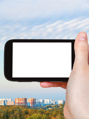 smartphone with cut out screen and city in autumn