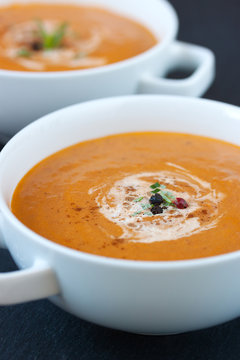 Vegetable soup with sun dried tomatoes and cream on a dark background