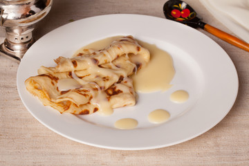 Pancakes with condensed milk in a rustic still life rural county