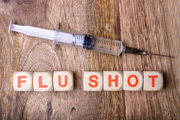 flu shot written with syringe on wood