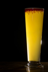 beer in glass with drops of blood in the dark 