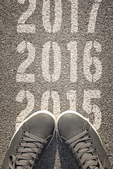 New shoes from above standing on 2016 stencil print on asphalt r