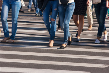 feet of pedestrians walking on the crosswalk