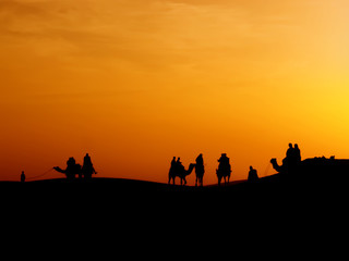 Fototapeta na wymiar silhouette of traveller who bought safari tour to see sunset at sand dune ,Thar desert,Jaisalmer,India