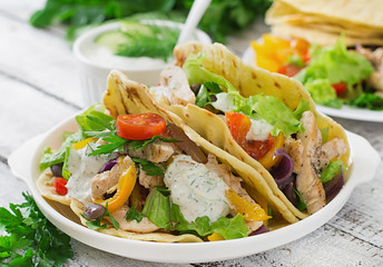 Mexican tacos with chicken, bell peppers, black beans and fresh vegetables and tartar sauce