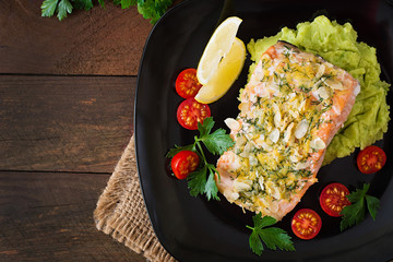 Baked salmon with cheese and almond crust and garnished with mashed potatoes and green peas