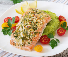 Baked salmon with cheese and almond crust and garnished with mashed potatoes and green peas